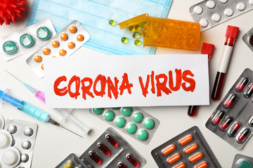 Flat lay composition with phrase CORONA VIRUS and medicines on white background