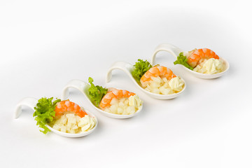 Snack with shrimp and apple in a glass boat on a white background