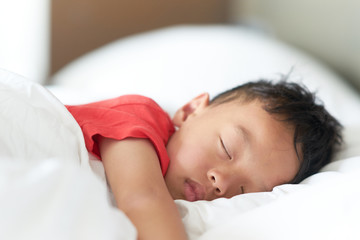 asian boy sleep or nap on comfortable pillow and bed in deep sleep