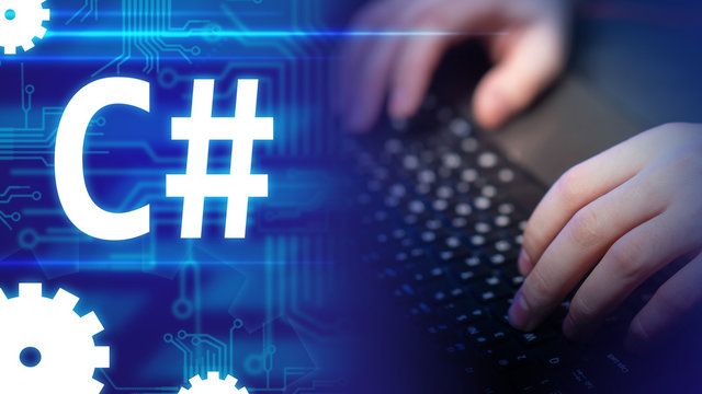 C#. Programming language C Sharp. Concept - work in the IT industry. Software testing. Development using C#. Learning C Sharp. Man is typing on a keyboard. Hands near the emblem C#.