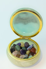 Bright colorful natural stones in jewelry box on a white background