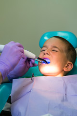 Dentists with a patient during a dental intervention to boy. Dentist Concept. At dentist's office. vertical photo