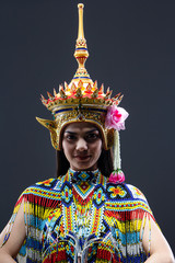 The beautiful woman wearing Thai southern folk dancing costume,made from colorful bead,put headdress on her head,model posing on solid backdrop