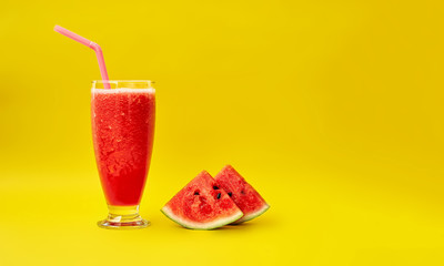 Watermelon smoothie and two slices of watermelon on a yellow background. Minimal style. Space for text