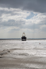 Fisherman boats stuck on the beach in low tide period.