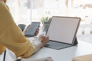 Business woman using smartphone with tablet in caffee shop. smart phone or mobile with blank screen and can be add your texts or otahers, tecnology concept.