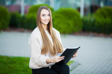 Obraz premium Business woman sitting on street near business center