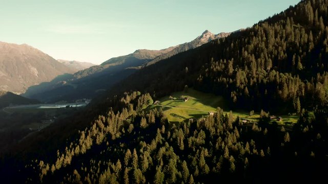 Sunset / sunrise on a green tree mountain side in a Austria valley with little houses