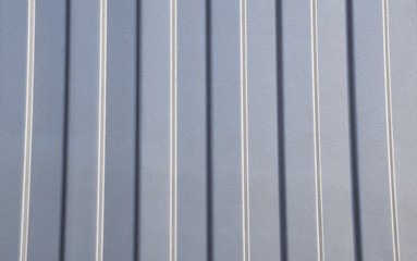 gray background from a metal wall, rhythmic vertical stripes