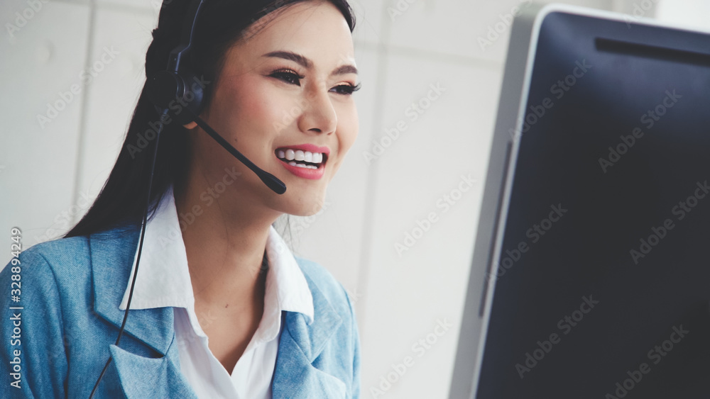 Poster customer support agent or call center with headset works on desktop computer while supporting the cu