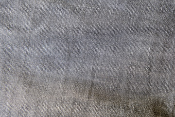 Fototapeta na wymiar Heavy used blue grey jean denim top view close up shot to the detail of fabric. textile material and cotton patter tough and durable garment style. For background or wallpaper with copy space for text