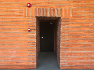 fire alarm bell and emergency door exit on brick wall