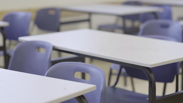 Pan across empty classroom in school or university - chairs and desks