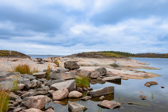 Russia. Ladoga lake. Ladoga on a background of blue sky. Karelian landscape on a sunny day. The nature of northern Russia. Large stones on the shore of Lake Ladoga. Rocks.Tour in Russia