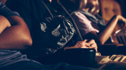 A man is secretly filming a video while watching a movie at the cinema