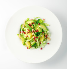 Green Salad with Avocado, Cucumber and Nuts on White Plate
