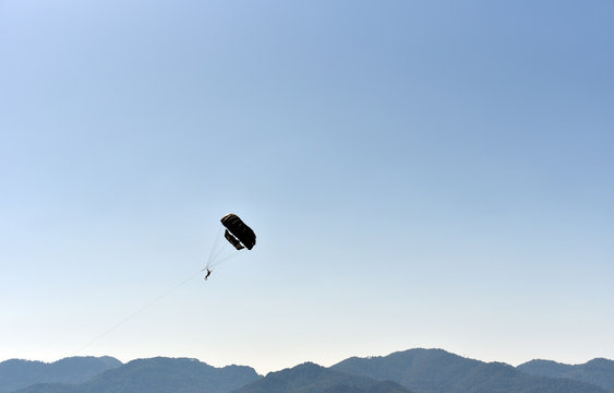 Parasailing (parascending Or Parakiting) - Human Flying On Parachute With Selfie Stick On Mountain Backgrounds