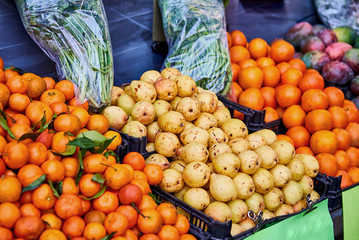 Orange tangerines with leaves and pears  lie on a counter in a fruit store top view. Mandarins in the market.