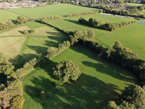 aerial view of parkland showing fields and hedgerows in evening sunshine