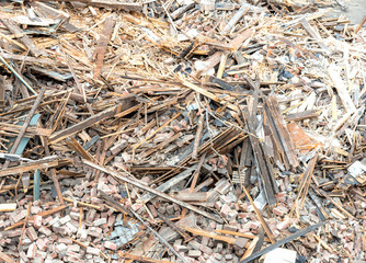 Closeup view of a large pile of rubble and debris from a demolished building. The pile consists of wood, brick, plaster, etc. 