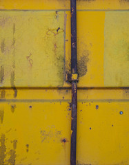 yellow metal wall with rusty pole