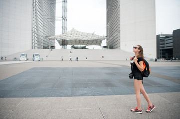 Summer vacation. Sightseeing guide. Girl tourist sunglasses enjoy city center square. Woman stand in front of urban architecture. Must visit place. Guide for tourists. Backpacker exploring city