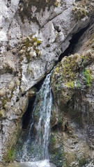 waterfall into the hight rocks of mountain area