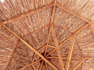 A projection of a straw canopy against a blue sky.