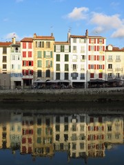 Obraz premium Bayonne, façades d’immeubles du quai Galuperie et reflet dans l'eau de la Nive (France)