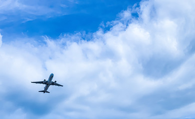 Fototapeta na wymiar airplane flying tacking off over head to blue sky and cloud.