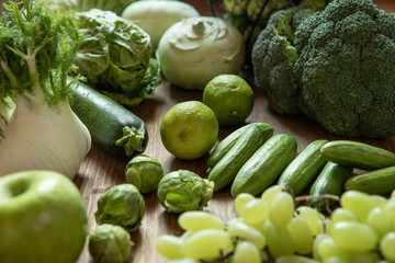 grünes Gemüse und Obst auf brauner Platte aus Holz