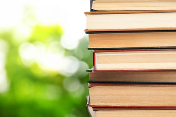 Collection of different books on blurred green background, space for text