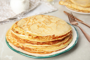 Stack of fresh thin pancakes on light grey marble table