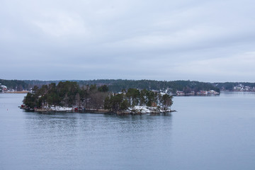 Fototapeta na wymiar An island with a few vacation houses near Stockholm, Sweden during a cold and gloomy winter morning.