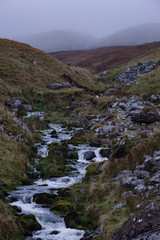 Fototapeta na wymiar River flowing down from misty mountain