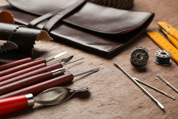 Leather samples and tools on brown table, closeup