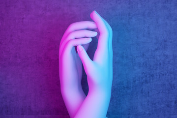 two hands in pink-blue lighting