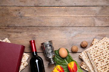 Flat lay composition with symbolic Pesach (Passover Seder) items on wooden table, space for text
