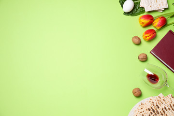 Flat lay composition with symbolic Pesach (Passover Seder) items on green background, space for text