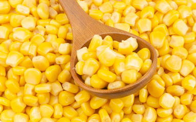 Canned corn with wooden spoon