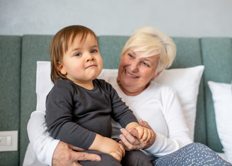 Grandma sitting and smiling with her grandson..