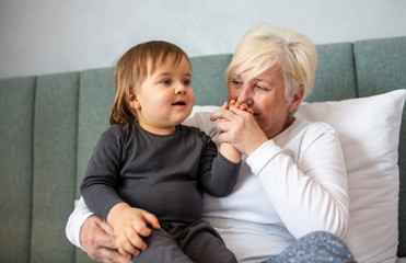 Grandma having fun and embracing her young grandson.
