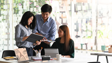 Photo of Ux Ui development team discussing/meeting/working together at the modern working table with comfortable and orderly decoration style office as background.