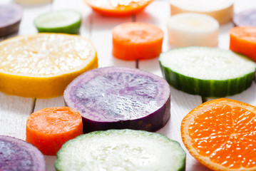 sliced fruits and vegetables on white wood table background