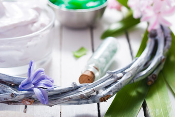 cosmetic cream product samples with hyacinth flowers on white wooden background