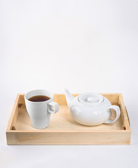Obraz na płótnie Canvas Teapot and cup on wood isolated on white