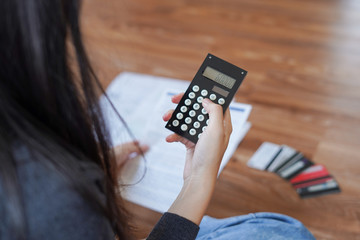 Young asian woman using calculator to calculate the bill after meet financial problem and credit card debt with no money to pay back feel stressed and worried.