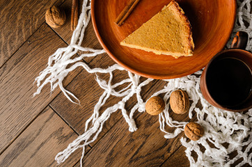 Homemade pumpkin pie on wooden rustic background top view. cake on a clay plate