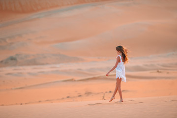 Girl among dunes in desert in United Arab Emirates