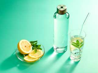 Refillable drinking water bottle on mint green background